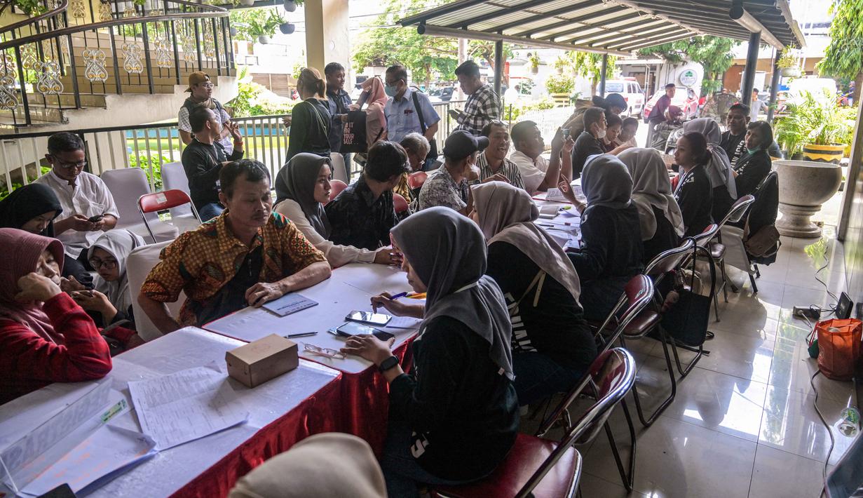 Bursa kerja ini juga bertujuan untuk memberi lebih banyak peluang kerja bagi penyandang disabilitas dengan bekerja sama dengan perusahaan-perusahaan yang menawarkan ratusan lowongan di berbagai bidang. Tampak dalam foto, para penyandang disabilitas menunggu untuk menyerahkan formulir lamaran mereka dalam bursa kerja yang diselenggarakan pemerintah daerah di Surabaya, Jawa Timur, pada Selasa 25 November 2025. (JUNI KRISWANTO/AFP)