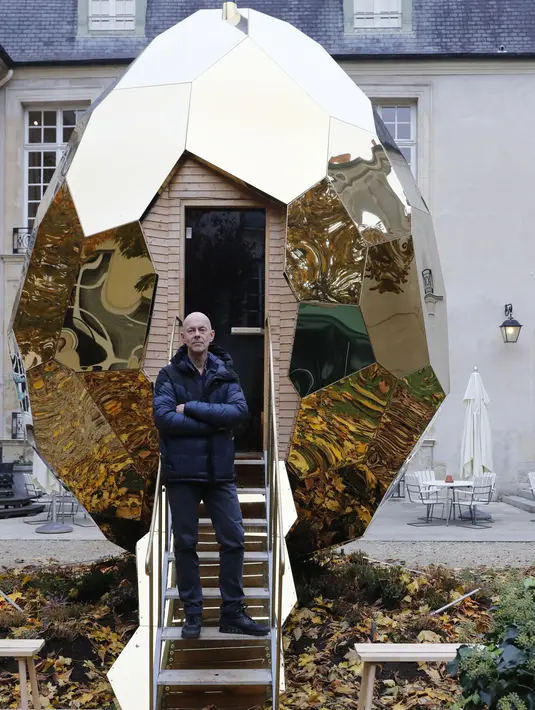 Seniman Mats Bigert berpose di depan Solar Egg, sebuah fasilitas sauna berbentuk telur raksasa di Institut Swedia di Paris, Rabu (15/11). Sauna berukuran 588x567x455 cm ini dibuat dari berbagai material seperti stainless steel. (PATRICK KOVARIK / AFP)