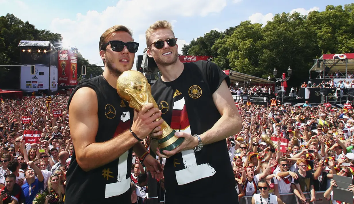 Mario Goetze (kiri) dan Andre Schuerrle berpose membelakangi suporter saat perayaan kemenangan Der Panzer di Berlin, (15/7/2014). (REUTERS/Alex Grimm/Pool)