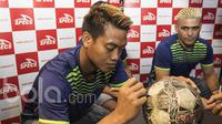 Kiper Arema FC, Kurnia Meiga, memberikan tanda tangan kepada bola milik penggemarnya saat menjadi bintang tamu pada acara jumpa fans di Toko Fisik Senayan City, Jakarta, Minggu (26/3/2017). (Bola.com/Vitalis Yogi Trisna)