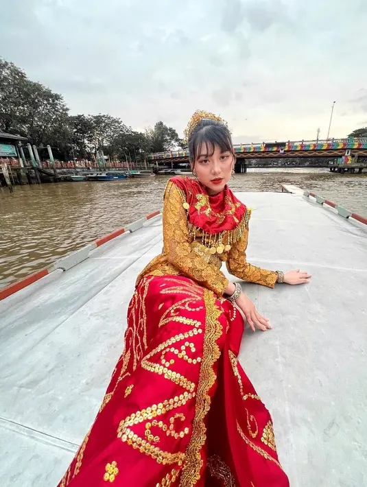 Perempuan kelahiran Singkawang itu melengkapi penampilannya dengan aksesori kepala warna emas.