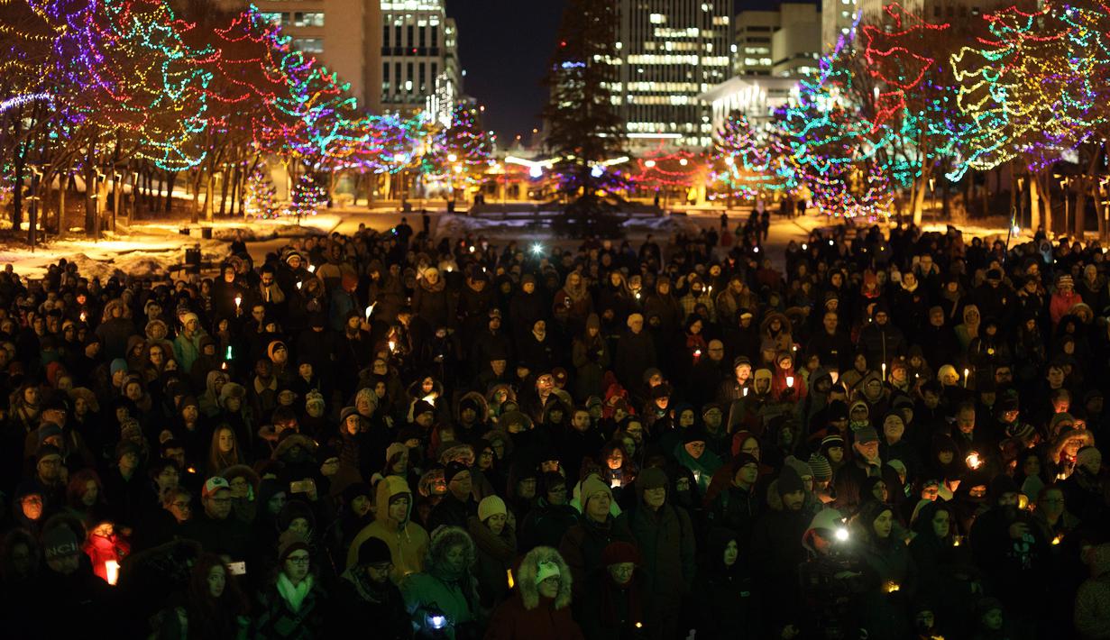 Ratusan orang berkumpul menyalakan lilin saat aksi dukungan pada komunitas muslim di Edmonton, Alberta, Senin (30/1). Dukungan itu setelah aksi penembakan di sebuah masjid di Quebec, Kanada yang menewaskan 6 orang (Jason Franson/The Canadian Press via AP)
