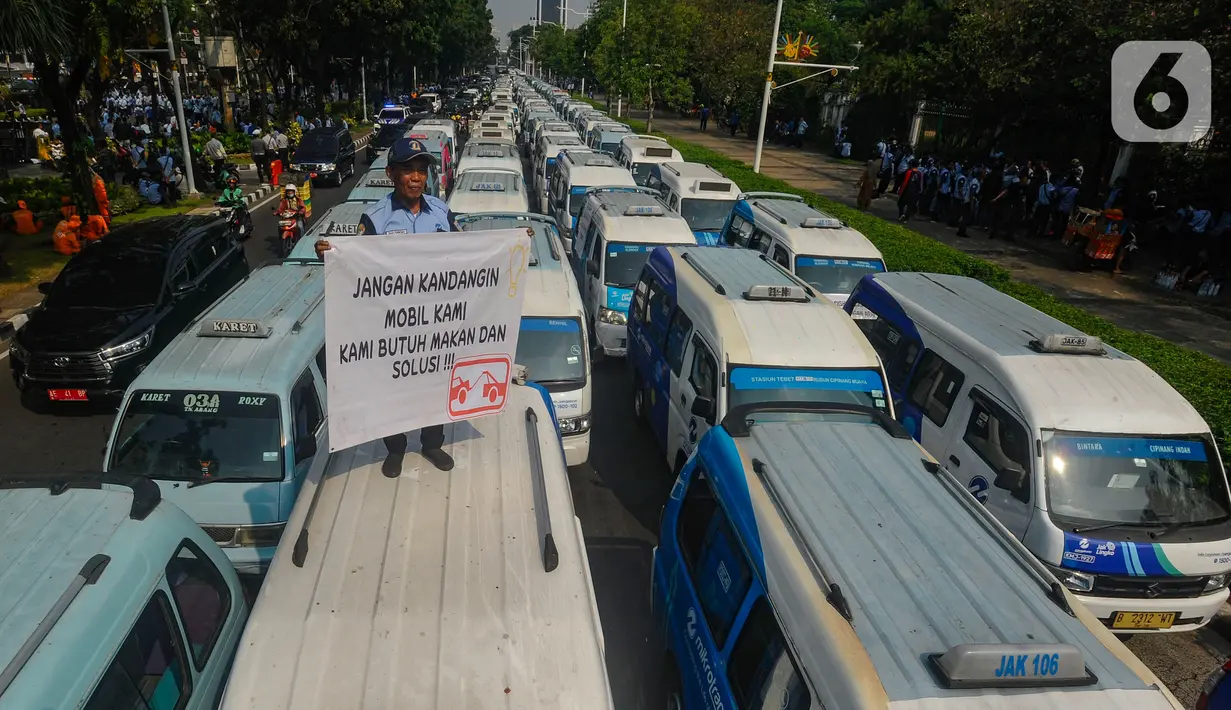 Mobil-mobil JakLingko Mikrotrans ini menggunakan hampir setengah badan jalan untuk parkir. (merdeka.com/Arie Basuki)