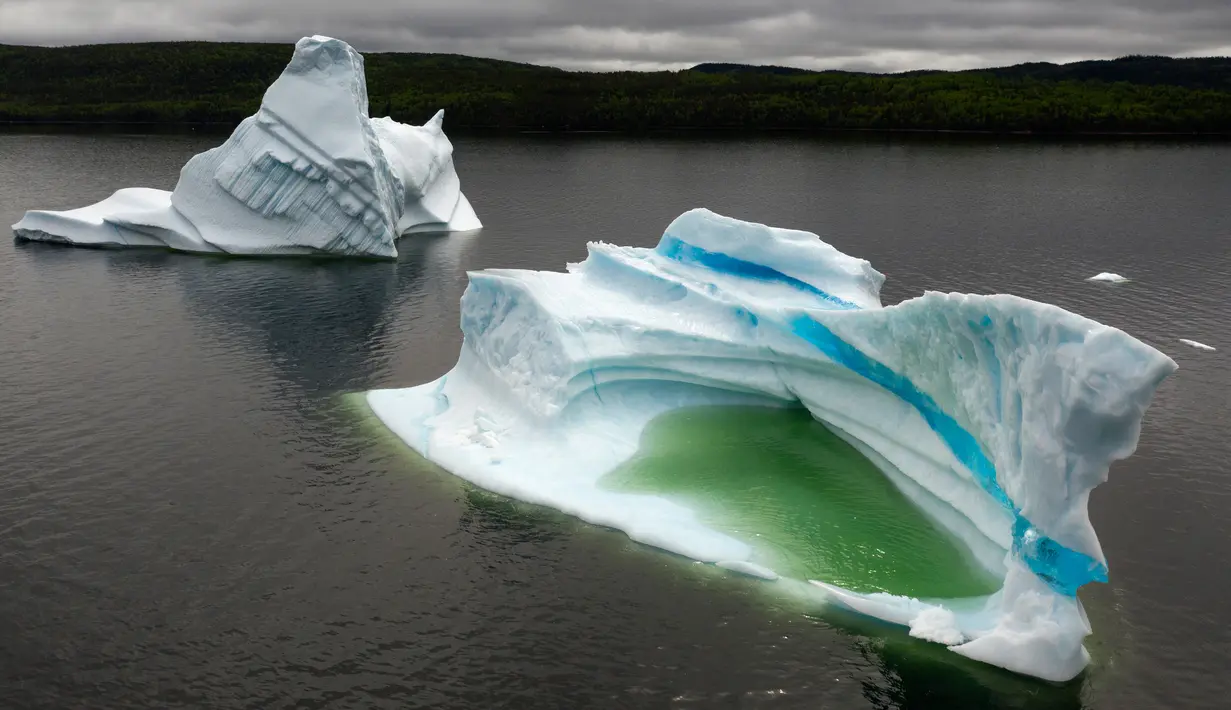 Pemandangan gunung es terapung di King's Point, Newfoundland, Kanada, 3 Juli 2019. Gunung es terapung tersebut dapat mencapai berat hingga ratusan ribu ton. (Johannes Eisele/AFP)