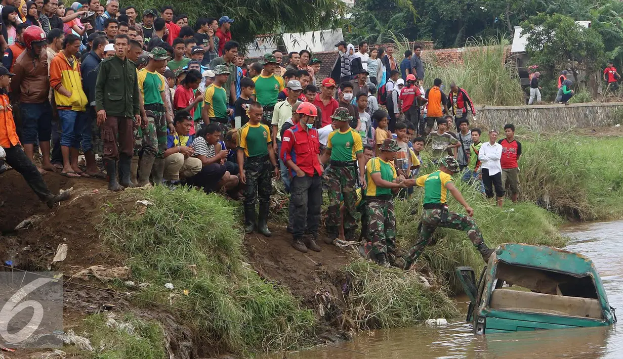 Prajurit Kostrad TNI AD bersama sukarelawan menyisir bangkai mobil yang diduga terdapat jenazah korban musibah banjir bandang di Cimacan, Garut (23/9). Data terakhir, tercatat sementara korban jiwa mencapai 26 orang. (Liputan6.com/Johan Tallo)