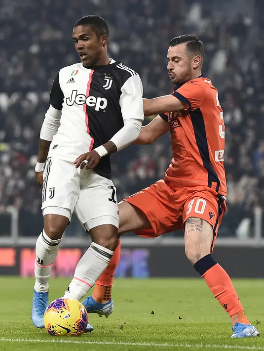 Pemain Juventus Douglas Costa (kiri) berebut bola dengan pemain Udinese Ilija Nestorovski pada pertandingan Coppa Italia 2019/2020 di Allianz Stadium, Turin, Italia, Rabu (15/1/2020).Juventus menang 4-0. (Fabio Ferrari/LaPress via AP)
