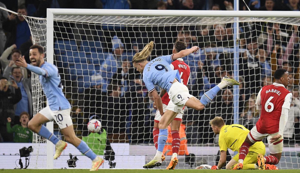 Striker Manchester City, Erling Haaland (tengah) mencetak gol keempat ke gawang Arsenal pada laga Liga Inggris 2022/2023 di Etihad Stadium, Manchester (26/4/2023). Setelah tiga kali beruntun menuai hasil imbang, Arsenal menelan kekalahan keempatnya di musim 2022/2023, lagi-lagi dari Manchester City. The Gunners takluk 1-4 saat bermain di kandang sendiri. (AFP/Oli Scarff)