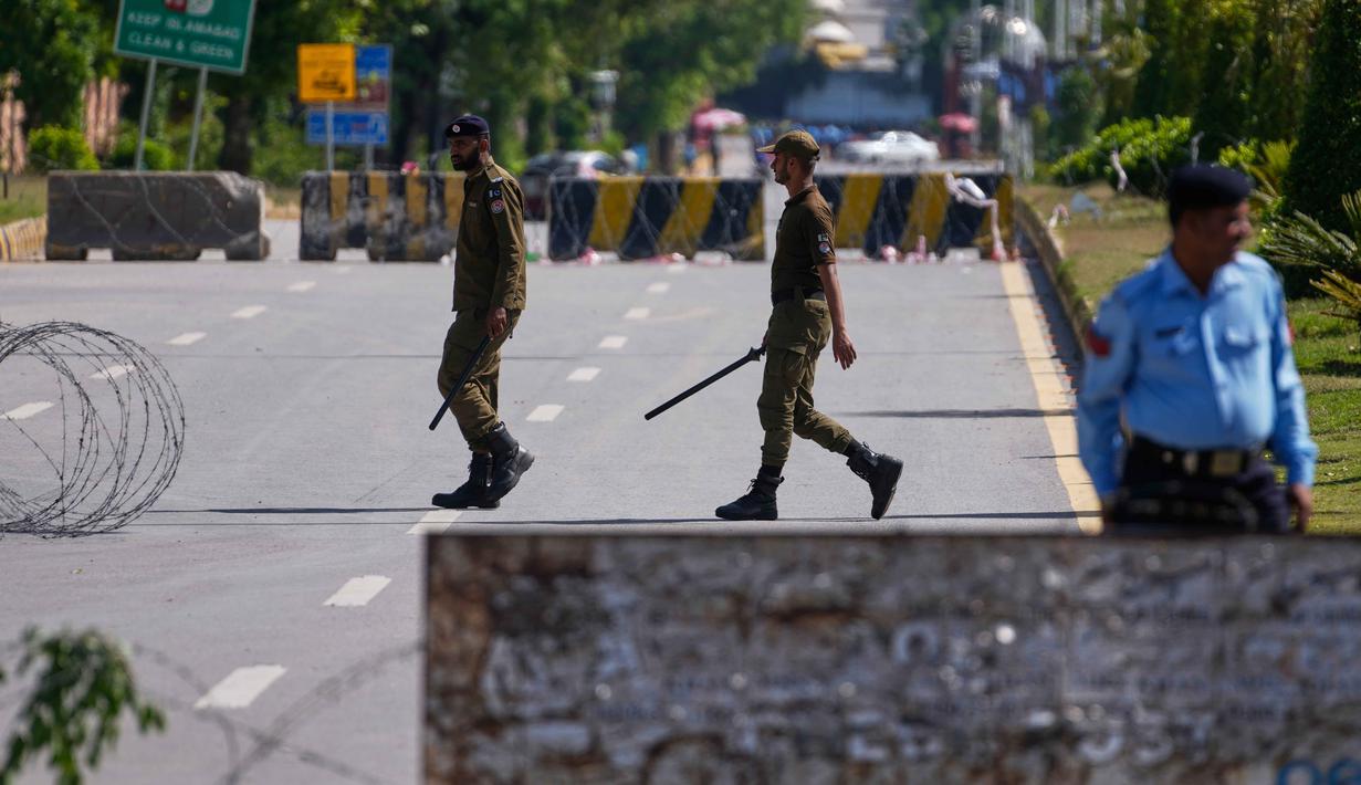 Sebagian wilayah kota Islamabad ditutup dan dijaga ketat. Tampak dalam foto, petugas polisi mengambil posisi di jalan yang dibarikade untuk memastikan keamanan menjelang kemungkinan negosiasi antara Amerika Serikat dan Iran di ibu kota Pakistan, Islamabad, Jumat 10 April 2026. (AP Photo/Anjum Naveed)