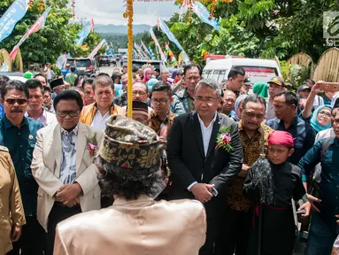Menteri Desa PDTT, Eko Putro Sandjojo dan Ketua DPD RI, Oesman Sapta Odang menerima sambutan dalam kunjungan kerja di Desa Bilalang, Kota Kotamobagu, Sulawesi Utara, Kamis (12/4). Mendes meninjau pelaksanaan program padat karya tunai. (Liputan6.com/Pool)