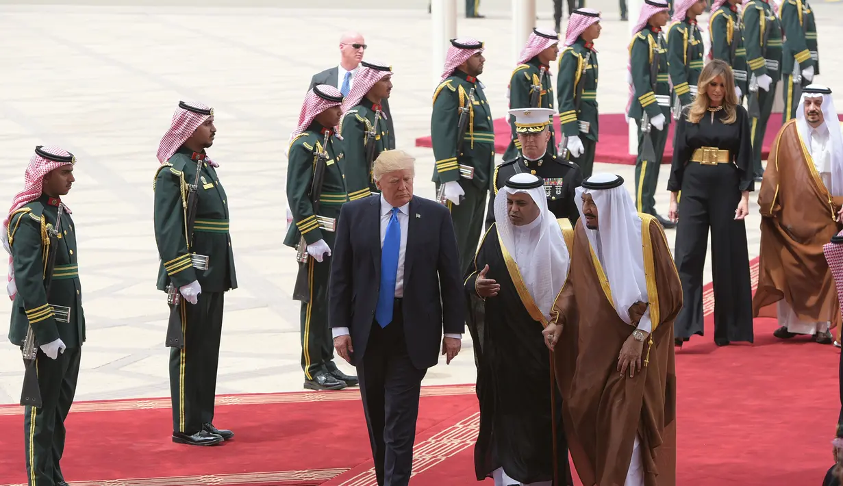Presiden AS Donald Trump berbincang dengan Raja Salman saat tiba di Bandara Internasional Raja Khalid di Riyadh (20/5). Kunjungan ini merupakan kunjungan luar negri Trump pertama sebagai Presiden AS. (AFP/Saudi Royal Palace/Bandar Al-Jalou)