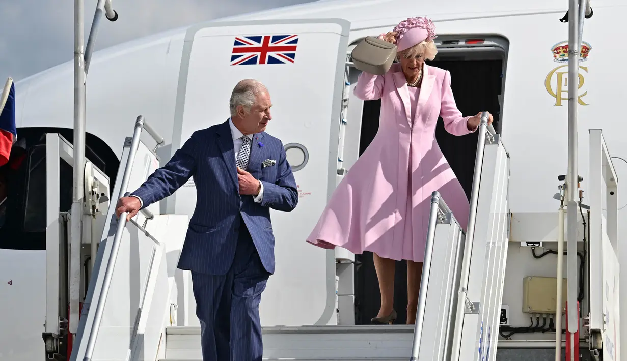 Raja Inggris Charles III (kiri) dan Ratu Inggris Camilla saat turun dari pesawat setibanya di Bandara Orly pada 20 September 2023. (Miguel MEDINA/POOL/AFP)