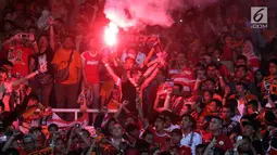 Suporter tim Macan Kemayoran menyalakan flare merayakan gelar juara Go-Jek Liga 1 Indonesia 2018 bersama Bukalapak yang diraih Persija di Stadion GBK, Jakarta, Minggu (9/12). Persija meraih gelar juara dengan 62 poin. (Liputan6.com/Helmi Fithriansyah)