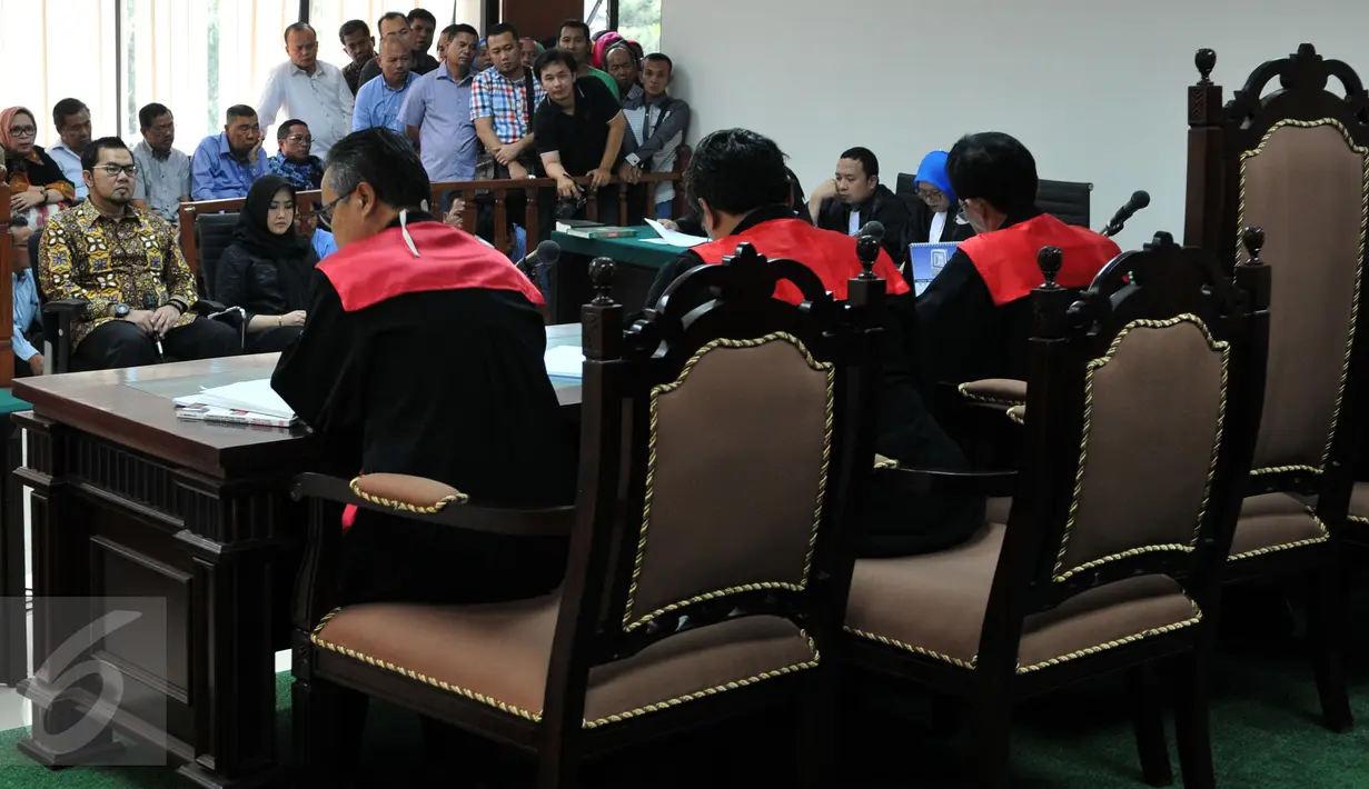 Bupati Empat Lawang Budi Antoni Aljufri dan istrinya, Suzannna mendengarkan jaksa KPK membacakan berkas dakwaan di Pengadilan Tipikor, Jakarta, Kamis (17/9). Keduanya diduga menyuap mantan Ketua MK Akil Mochtar. (Liputan6.com/Andrian M Tunay)