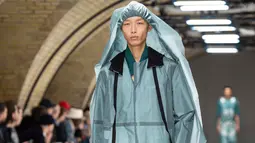 Model membawakan busana kreasi dari perancang Inggris, Craig Green selama gelaran London Fashion Week Men's di London pada 7 Januari 2019. Craig Green menampilkan busana warna-warni berbahan plastik minyak dengan pola yang rumit. (NIKLAS HALLE'N/AFP)