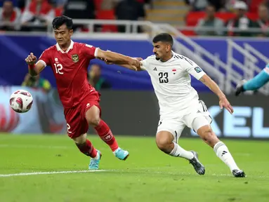 Pemain Timnas Indonesia Pratama Arhan berebut bola dengan pemain Irak Merchas Ghazi Salih pada pertandingan sepak bola Grup D Piala Asia di Stadion Ahmad Bin Ali, Al Rayyan, Qatar, Senin (15/1/2024). Timnas Indonesia memulai petualangan di Piala Asia 2023 dengan mengecewakan setelah kalah 1-3 ketika menghadapi Irak. (AP Photo/Hussein Sayed)