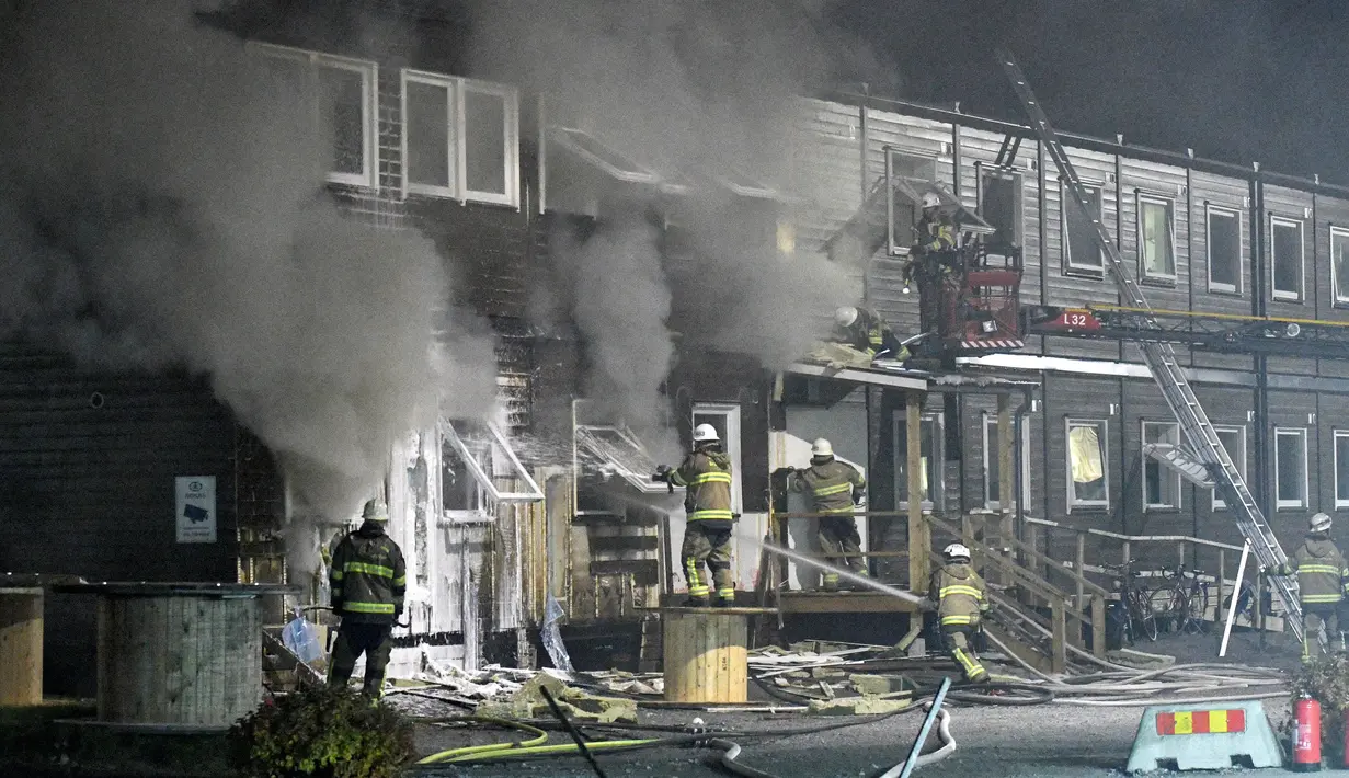 Sebuah tempat pengungsi di Fagersjo terbakar, Stockholm, Swedia pada Minggu (16/10) malam. Petugas pemadam kebakaran berusaha memadamkan api yang berkobar dari dalam gedung. (REUTERS/TT News Agency / Johan Nilsson)