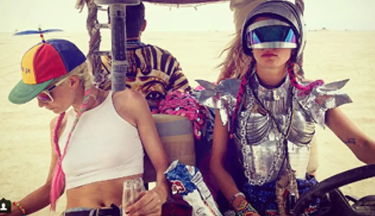 Model Poppy dan Cara Delevingne menaiki mobil saat menghadiri festival seni Burning Man di Nevada, AS. Festival tahunan ini telah berjalan 30 tahun.  (Instagram.com/derekblasberg)