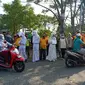 Petugas yang mengenakan pakaian mirip pocong dihadirkan saat razia masker di jalan protokol dan pasar tradisional di Kota Bekasi, Rabu (16/9/2020). (Liputan6.com/Bam Sinulingga)