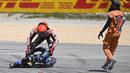 Pebalap Repsol Honda, Marc Marquez (atas) berusaha menolong pebalap CryptoData Aprilia, Miguel Oliveira setelah insiden tabrakan pada balapan MotoGP Portugal 2023 di Sirkuit Internasional Algarve, Portimao, Portugal, Minggu (26/3/2023). (AFP/Patricia De Melo Moreira)