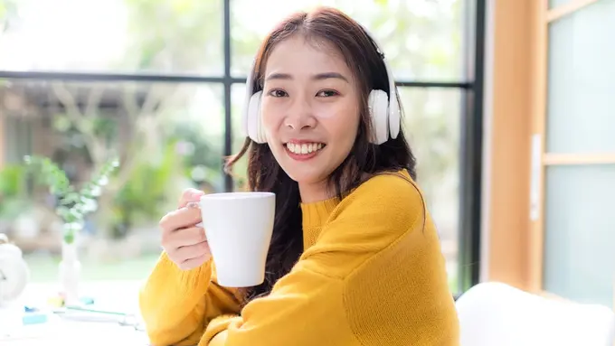 perempuan baju kuning mendengarkan musik