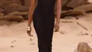 <p>Naomi Campbell berjalan di runway Off-White Fall/Winter 2023-2024 pada acara Paris Fashion Week, Prancis, Kamis, 2 Maret 2023. Gaun Naomi menampilkan bentuk tubuh yang pas dengan garis leher berhiaskan permata yang kebesaran, dipasangkan dengan sepatu bot bertumit dan gelang emas tebal. (Vianney Le Caer/Invision/AP)</p>