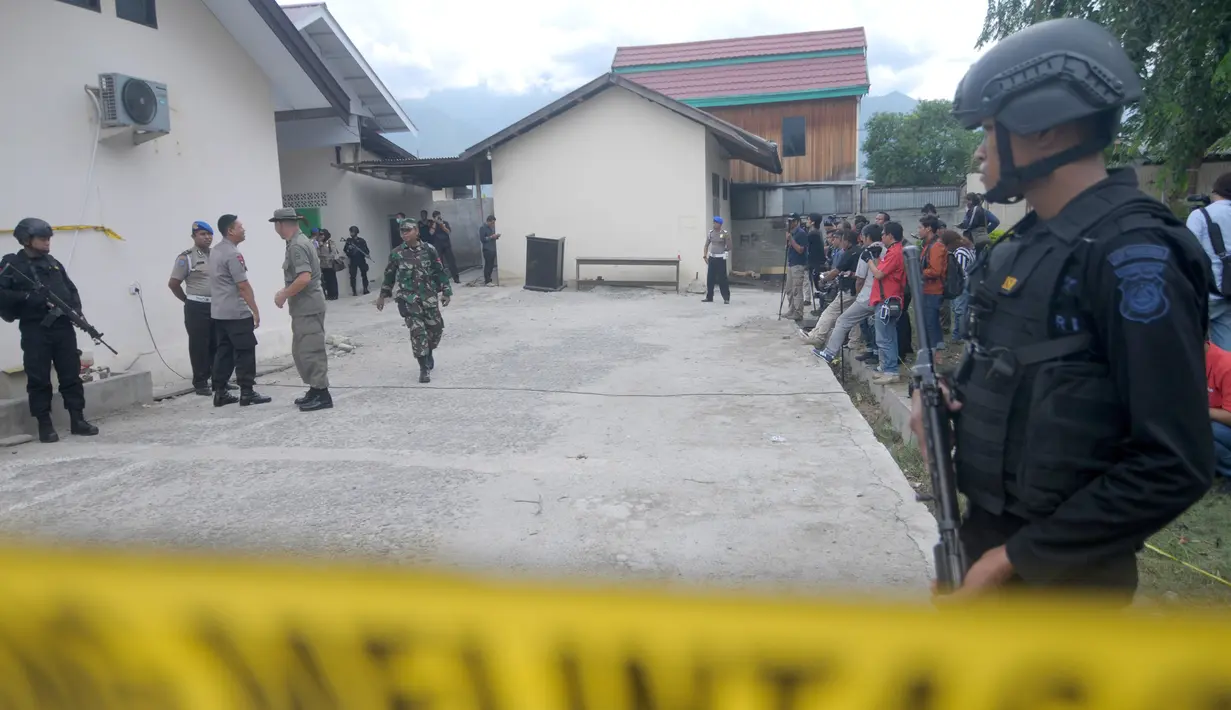 Sejumlah polisi bersenjata disiagakan disekitar RS Bhayangkara Palu, Sulawesi Tengah, Selasa (17/7). Dua jenazah diduga teroris Santoso alias Abu Warda dan Muhtar yang tewas dalam baku tembak tiba di RS tersebut untuk diidentifikasi. (OLAGONDRONK/AFP)
