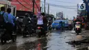 Sejumlah pengendara melintasi jalan berlubang dan tergenang air di Jalan Raya Pabuaran, Citayam, Depok, Rabu (26/2/2020). Kerusakan disebabkan oleh kubangan air yang menggenangi jalan tersebut pada musim hujan  yang melanda Jabodetabek dua bulan terakhir. (merdeka.com/magang/Muhammad Fayyadh)