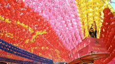 Para pekerja memasang lentera teratai di Kuil Jogyesa, Seoul, Korea Selatan, Jumat (26/5/2023). Pemasangan lentera dilakukan jelang perayaan ulang tahun Buddha pada 27 Mei. (Jung Yeon-je/AFP)