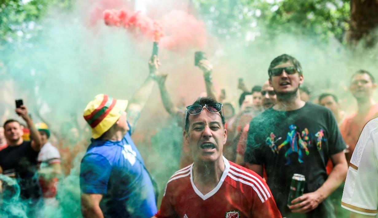 Suporter Wales berpesta setelah Wales menang 3-0 atas Rusia pada laga grup B Piala Eropa 2016 di Stadion Municipal, Toulouse, Selasa (21/6/2016) dini hari WIB. Wales lolos ke 16 Besar. (AFP/Bulent Kilic)