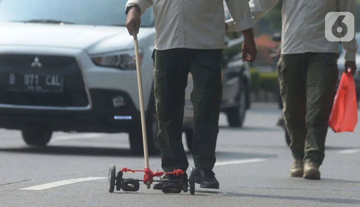 Petugas Satpol PP melakukan operasi pembersihan ranjau paku di Jalan Gatot Subroto, Jakarta, Sabtu (16/10/2021). Kegiatan penertiban ranjau paku ini untuk memberikan rasa aman dan nyaman bagi pengendara saat melintas di jalanan. (merdeka.com/Imam Buhori)