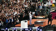 Rapper Prancis, Julien Mari alias Jul lights menyalakan api di kuali relai obor saat upacara penyambutan kedatangan api Olimpiade dan Paralimpiade Paris 2024 di Vieux-Port (Pelabuhan Tua) Marseille, Pranci, Rabu (08/05/2024) waktu setempat. (AFP/Christophe Simon)