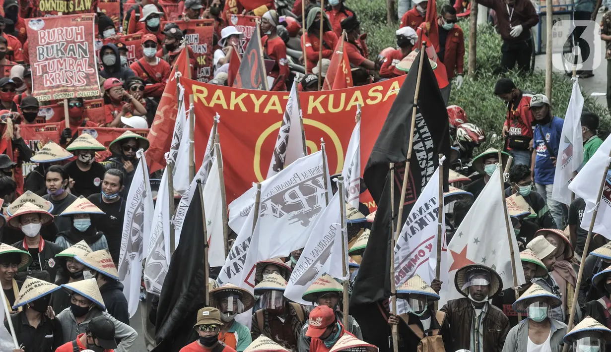 Massa buruh dan tani saat menggelar longmarch menuju Istana Negara di Jalan Salemba Raya, Jakarta, Selasa (20/10/2020). Mereka juga mendesak Presiden Joko Widodo segera menerbitkan Perppu pembatalan UU Cilaka. (merdeka.com/Iqbal S. Nugroho)