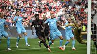 Bek Bayer Leverkusen asal Inggris #04, Jarell Quansah (tak terlihat), mencetak gol 1-0 melewati kiper Hoffenheim asal Jerman #37 Luca Philipp (kanan) dalam pertandingan divisi satu Bundesliga Jerman antara Bayer 04 Leverkusen dan TSG 1899 Hoffenheim di Leverkusen, Jerman Barat pada 23 Agustus 2025. (INA FASSBENDER/AFP)