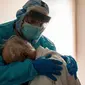 Dr. Joseph Varon menghibur pasiennya di unit perawatan intensif COVID-19 di United Memorial Medical Center di Houston, Texas. (Photo credit: Go Nakamura/Getty Images/AFP)