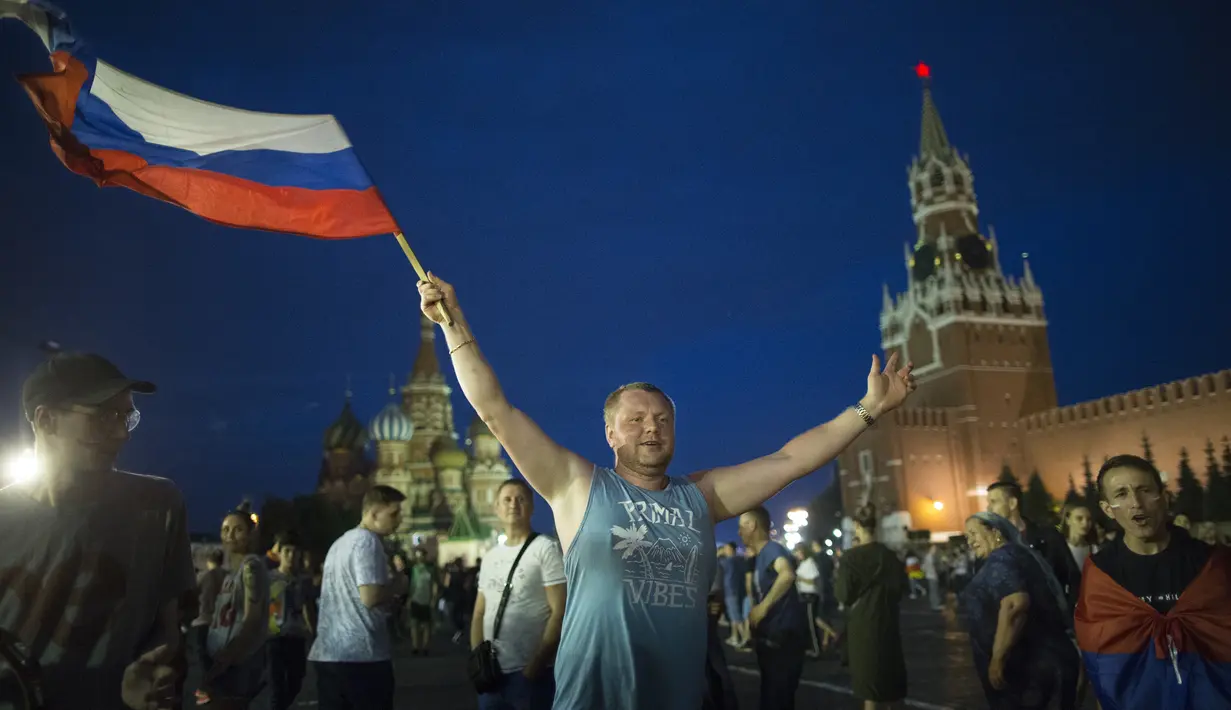Suporter Rusia berpesta merayakan keberhasilan negaranya mengalahkan Spanyol pada laga 16 besar Piala Dunia di Moskow, Minggu (1/7/2018). Rusia untuk pertama kalinya lolos ke babak perempatfinal. (AFP/Alexander Zemlianichenko)