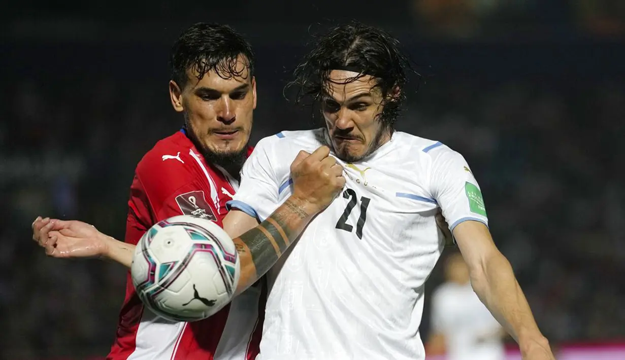 Pemain Paraguay Gustavo Gomez (kiri) berebut bola dengan pemain Uruguay Edinson Cavani pada pertandingan sepak bola kualifikasi Piala Dunia 2022 di Stadion General Pablo Rojas, Asuncion, Paraguay, 27 Januari 2022. Uruguay menang 1-0. (AP Photo/Jorge Saenz)