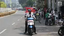 Pengendara motor melintasi arena Car Free Day (CFD) di Jalan Warung Jati Barat, Jakarta, Minggu (17/9).  Beberapa pengendara motor terlihat bebas menerabas jalan yang dipenuhi orang yang sedang berolahraga dan berjualan. (Liputan6.com/Immanuel Antonius)