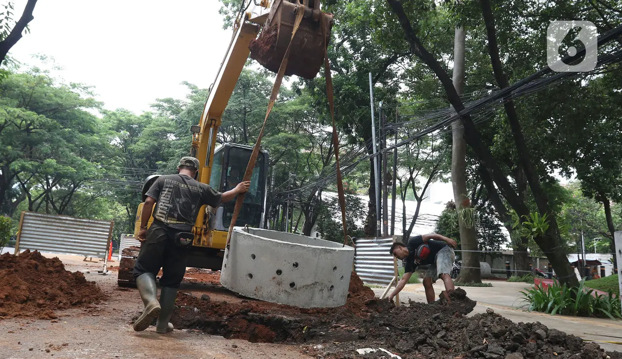 Pekerja sedang menyelesaikan pengerjaan sumur resapan di Jalan Mataram Raya, Kebayoran Baru, Jakarta, Selasa (12/10/2021). Sumur resapan atau drainase vertikal tersebut diharapkan dapat mengurangi titik-titik rawan banjir di Ibu Kota. (Liputan6.com/Herman Zakharia)
