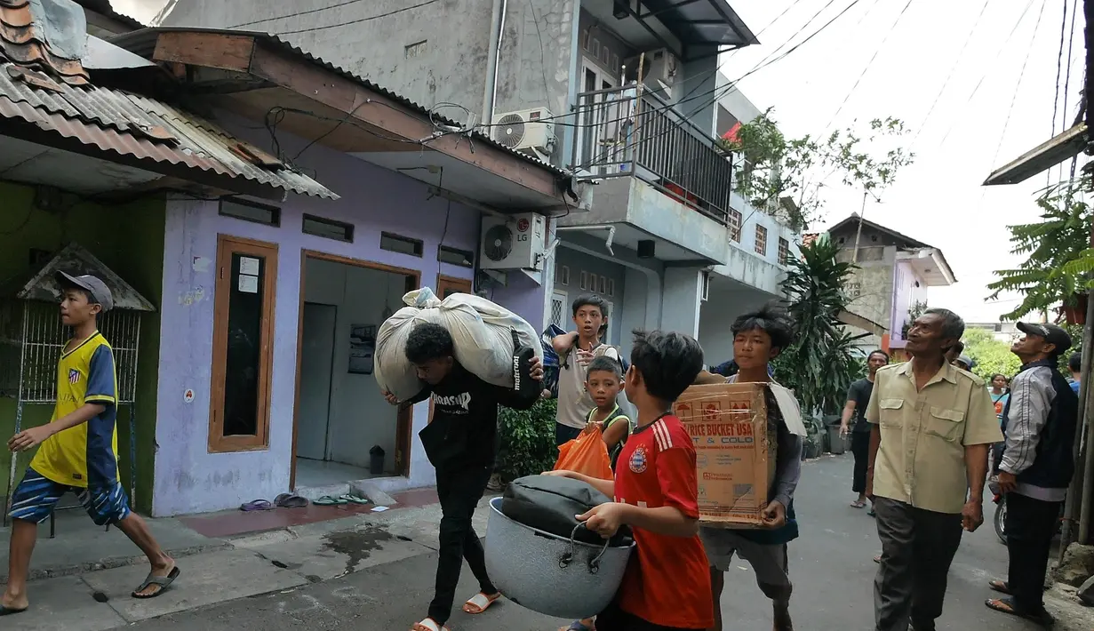 Warga berusaha menyelamatkan harta benda mereka ketika kebakaran melanda permukiman padat penduduk di Manggarai, Jakarta, Rabu (10/7/2019). Hingga saat ini sebanyak 28 unit mobil pemadam kebakaran dikerahkan di lokasi kejadian yang tak jauh dari Stasiun Kereta Api. (Liputan6.com/Herman Zakharia)