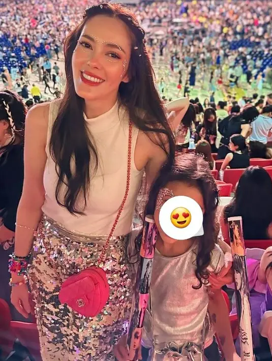 Cathy Sharon tampil dengan tanktop putih halter neck dipadukan rok sequin silver dengan menambahkan manik-manik pada wajahnya. [@cathysahron]