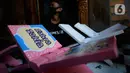 Perajin, Seno (47), menyelesaikan lukisan rekal atau tatakan Al Quran untuk anak-anak di Perumahan Gading Depok, Curug, Bojongsari, Depok, Jumat (25/09/2020). Di masa pandemi, tatakan Al Quran dan talenan lukis yang dijual seharga Rp 50 ribu mengalami penurunan pemesanan. (merdeka.com/Dwi Narwoko)