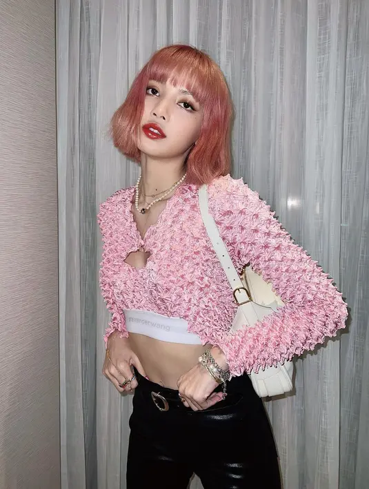 Dengan rambut dan outfit berwarna merah muda, Lisa tampil menawan. Kenakan bralette yang serasi dengan cropped top lengan panjangnya yang berwarna merah muda, Lisa memadukan tampilannya dengan celana panjang hitam. Foto: Instagram.