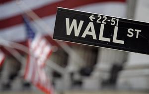 Dalam file foto 11 Mei 2007 ini, tanda Wall Street dipasang di dekat fasad terbungkus bendera dari Bursa Efek New York. (Richard Drew/AP Photo)