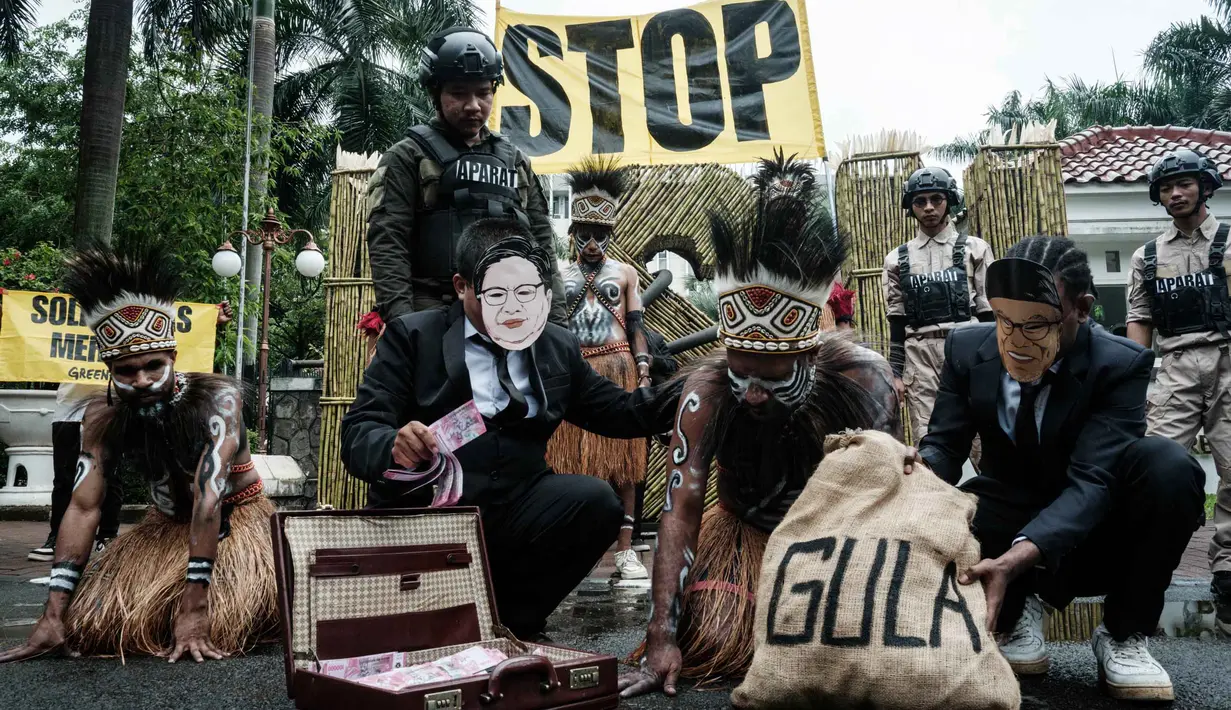 Aktivis Greenpeace Indonesia bersama beberapa pemuda Papua menggelar aksi teatrikal saat berunjuk rasa di depan Kantor Kementerian Koordinator bidang Perekonomian, Jakarta, Kamis (18/12/2025). Aktivis Greenpeace Indonesia bersama beberapa pemuda Papua menggelar aksi damai di depan Kantor Kementerian Koordinator bidang Perekonomian, Jakarta. (Yasuyoshi Chiba/AFP)