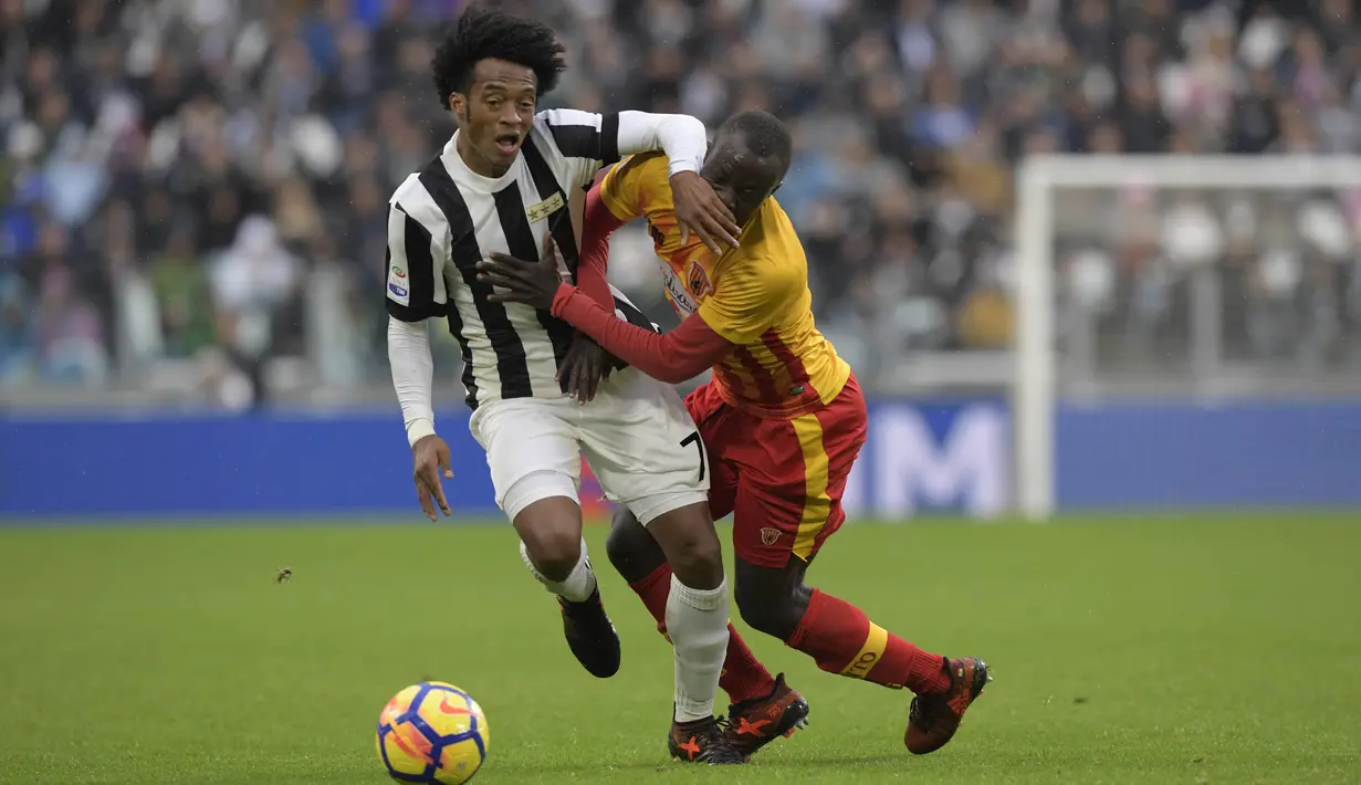 Gelandang Juventus, Juan Cuadrado, berebut bola dengan gelandang Benevento, Yussif Chibsah, pada laga Serie A Italia di Stadion Allianz, Turin, Minggu (5/11/2017). Juventus menang 2-1 atas Benevento. (AFP/Miguel Medina)