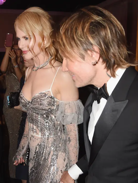 Nicole Kidman bersama musisi Keith Urban berjalan saat menghadiri Golden Globe Awards 2017 di Beverly Hilton, Beverly Hills, California, AS (8/1). (AFP Photo/Valerie Macon)