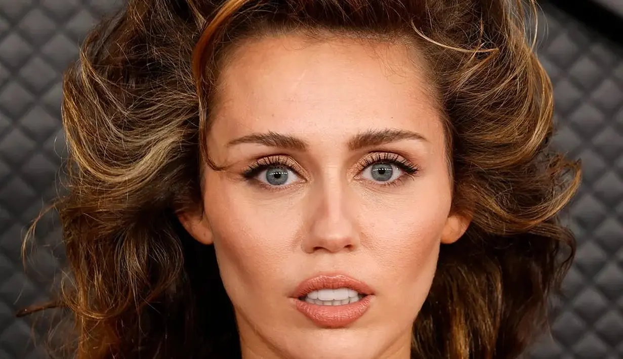 Rambut ikal Miley Cyrus yang super menggoda membawakan drama terbaik ke karpet merah Grammy. Dia menjaga riasannya cukup sederhana, dengan kontur wajah tegas, nude lipstick,  dan sentuhan cat eyeliner yang halus oleh MUA James Kaliardos. [@russellmpls]