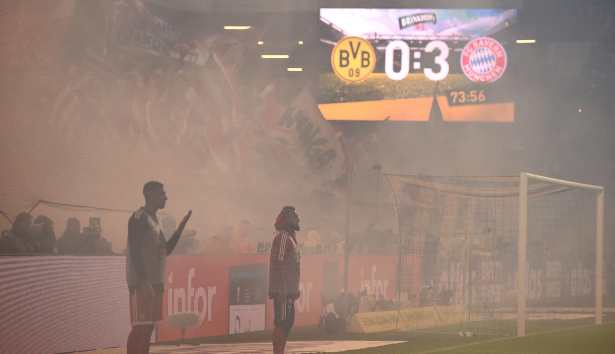 Asap tebal dari flare menyelimuti lapangan saat laga Borussia Dortmund melawan Bayern Munchen pada lanjutan Bundesliga di Signal Iduna Park, Dortmund, (4/11/2017). Bayern menang 3-1. (AFP/Patrik Stollarz)