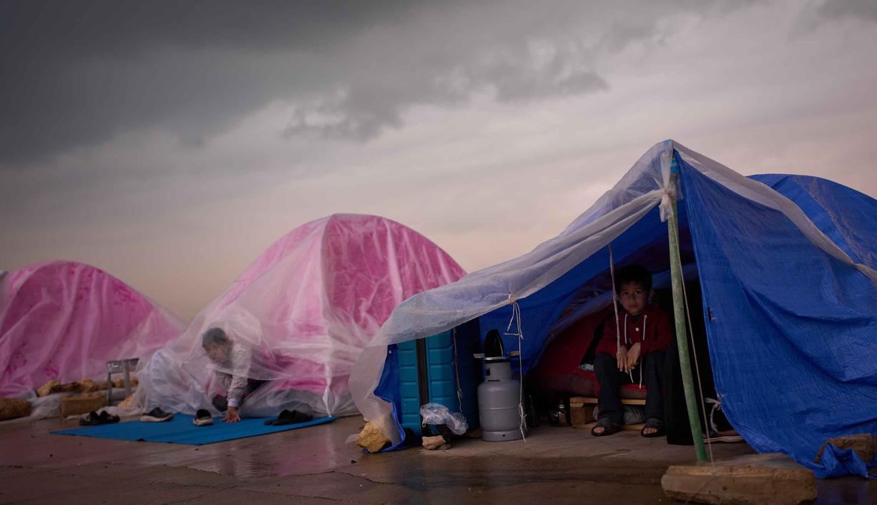 Perserikatan Bangsa Bangsa (PBB) melaporkan lebih dari satu juta orang di Lebanon, dalam beberapa pekan terakhir, meninggalkan rumah mereka untuk tinggal di lokasi yang aman dari ancaman serangan udara Israel, dengan sekitar sepertiga di antaranya adalah anak-anak. Tampak dalam foto, anak-anak pengungsi dari pinggiran selatan Beirut, Dahiyeh, berlindung dari hujan di dalam tenda mereka di sepanjang pantai, Beirut, Lebanon, Kamis, 26 Maret 2026. (AP Photo/Emilio Morenatti)
