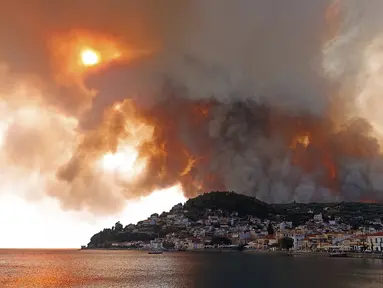 Api berkobar di gunung dekat Desa Limni, Pulau Evia, sekitar 160 kilometer (100 mil) utara Athena, Yunani, Selasa (3/8/2021). Yunani bergulat dengan gelombang panas terburuk dalam beberapa dasawarsa. (AP Photo/Michael Pappas)